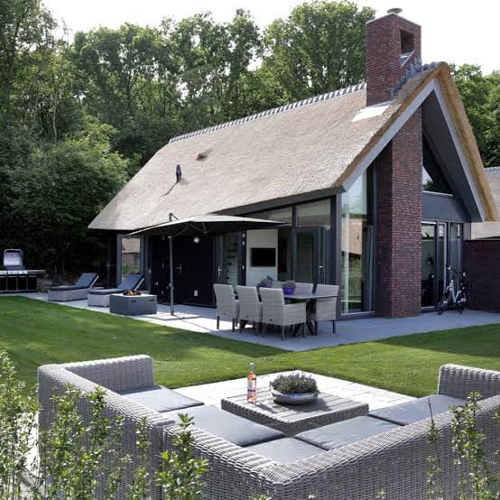 Vakantiehuis met rieten kap, terras en loungeset